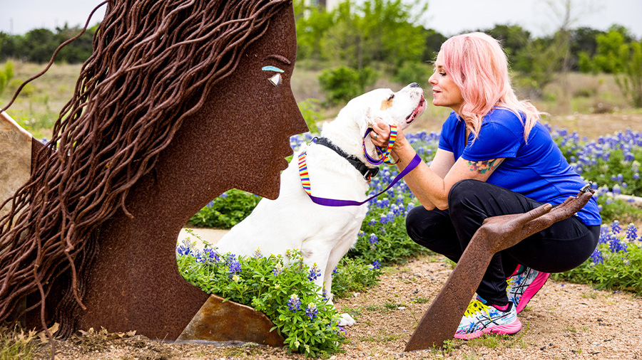Woman with white dog outdoors in in Austin, TX
