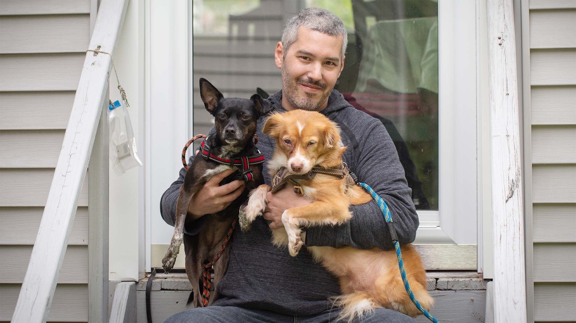 Man holding 2 dogs