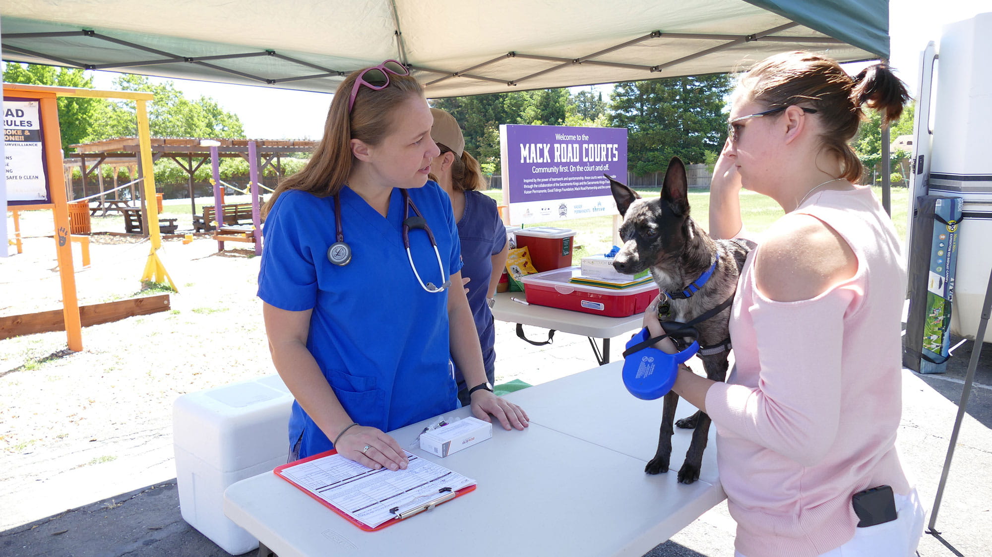 Dr. Anne Kimmerlein at a vaccine clinic talking with a client and patient